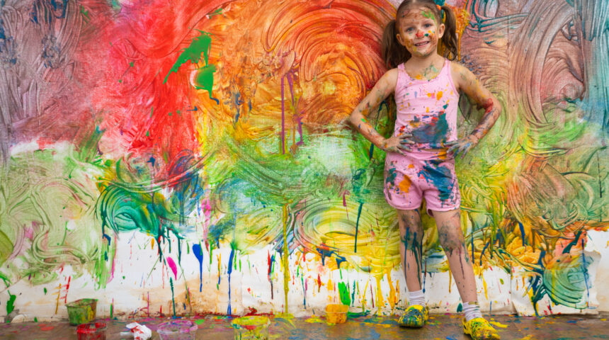 Little Girl Child Preschooler Draws Hands Paints On White Wall. Artysta, czyli kto?